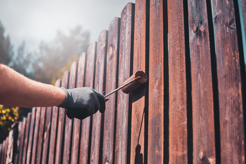 Staining a wooden fence with a roller