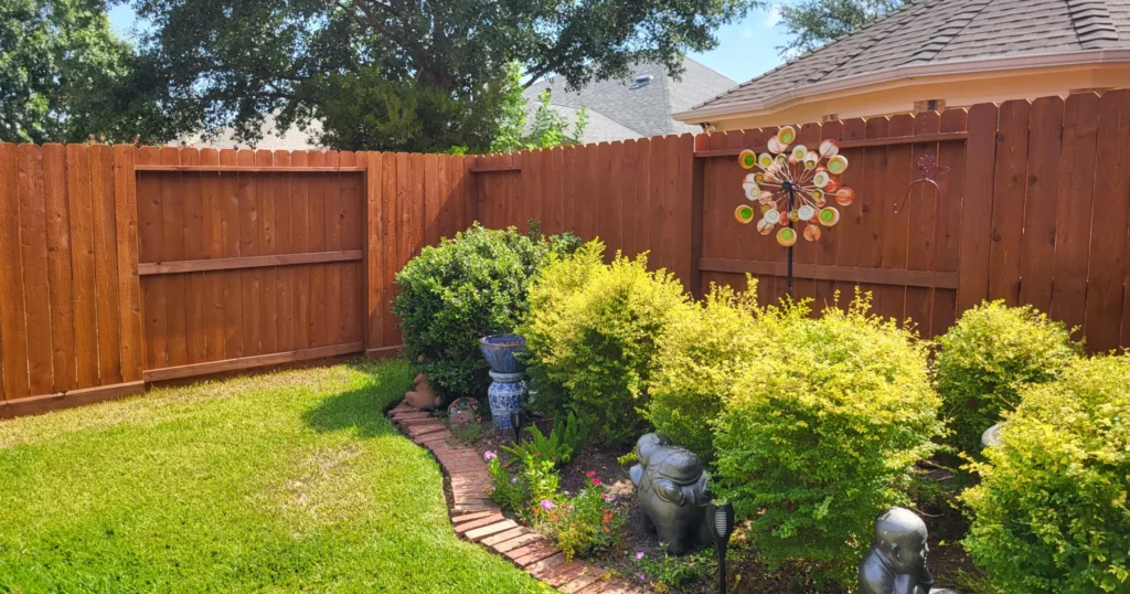 Painting vs Staining a Fence in Houston, TX: Which is Better in 2025? 2 Well-prepared Houston backyard ready for fence staining with trimmed shrubs cleared area and beautiful stained wooden fence