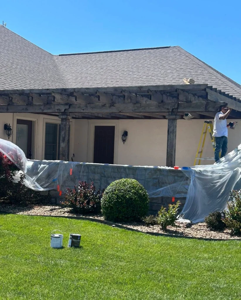 Pergola Staining 7 Professional pergola staining process showing extensive masking and plastic sheeting protecting home siding windows and landscaping from overspray