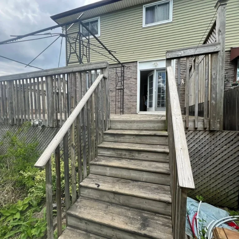 Weathered elevated deck stairs before staining Houston showing aged gray wood railings needing professional restoration treatment residential property