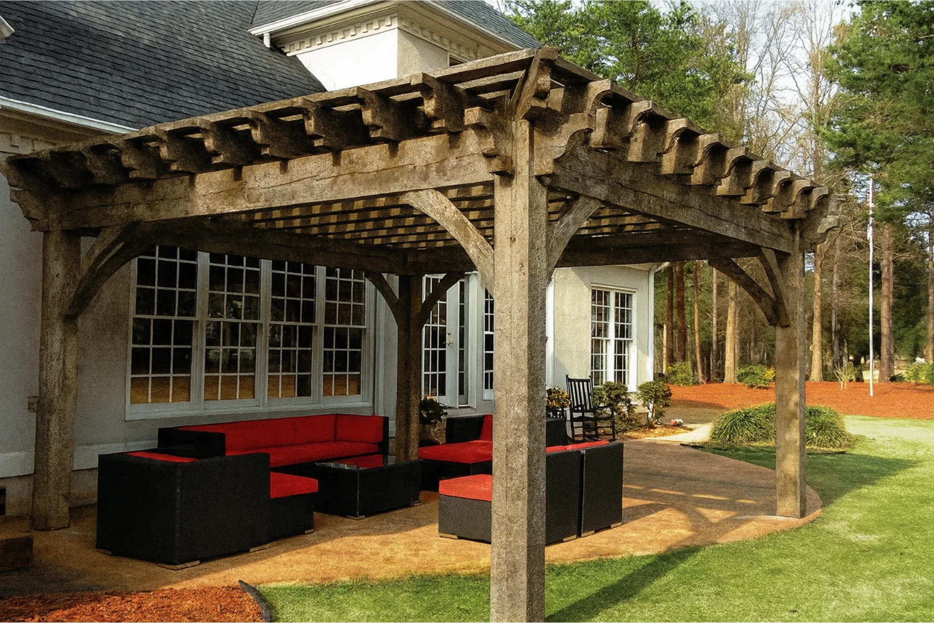Weathered unstained pergola attached to home showing gray wood and UV damage needing professional pergola staining company service