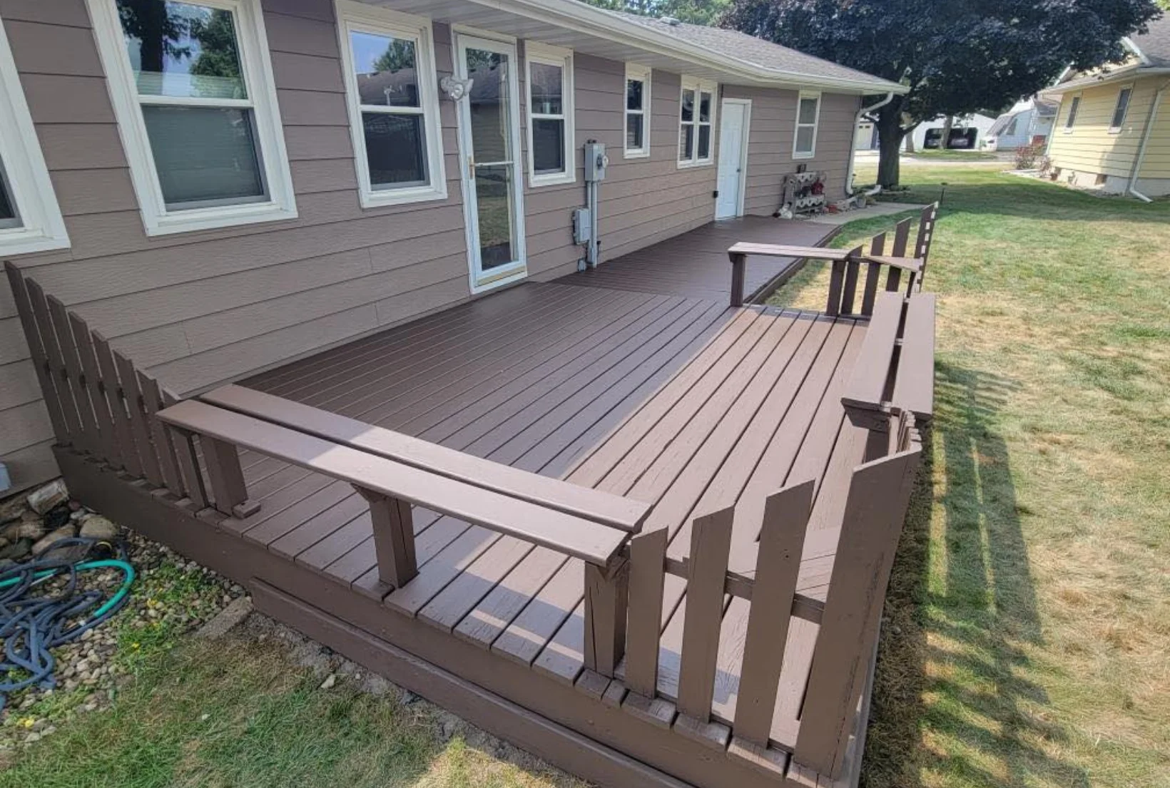 deck-staining-after-dark-brown-finish-houston Freshly stained deck with built-in benches and railings in rich dark brown solid stain finish after professional service