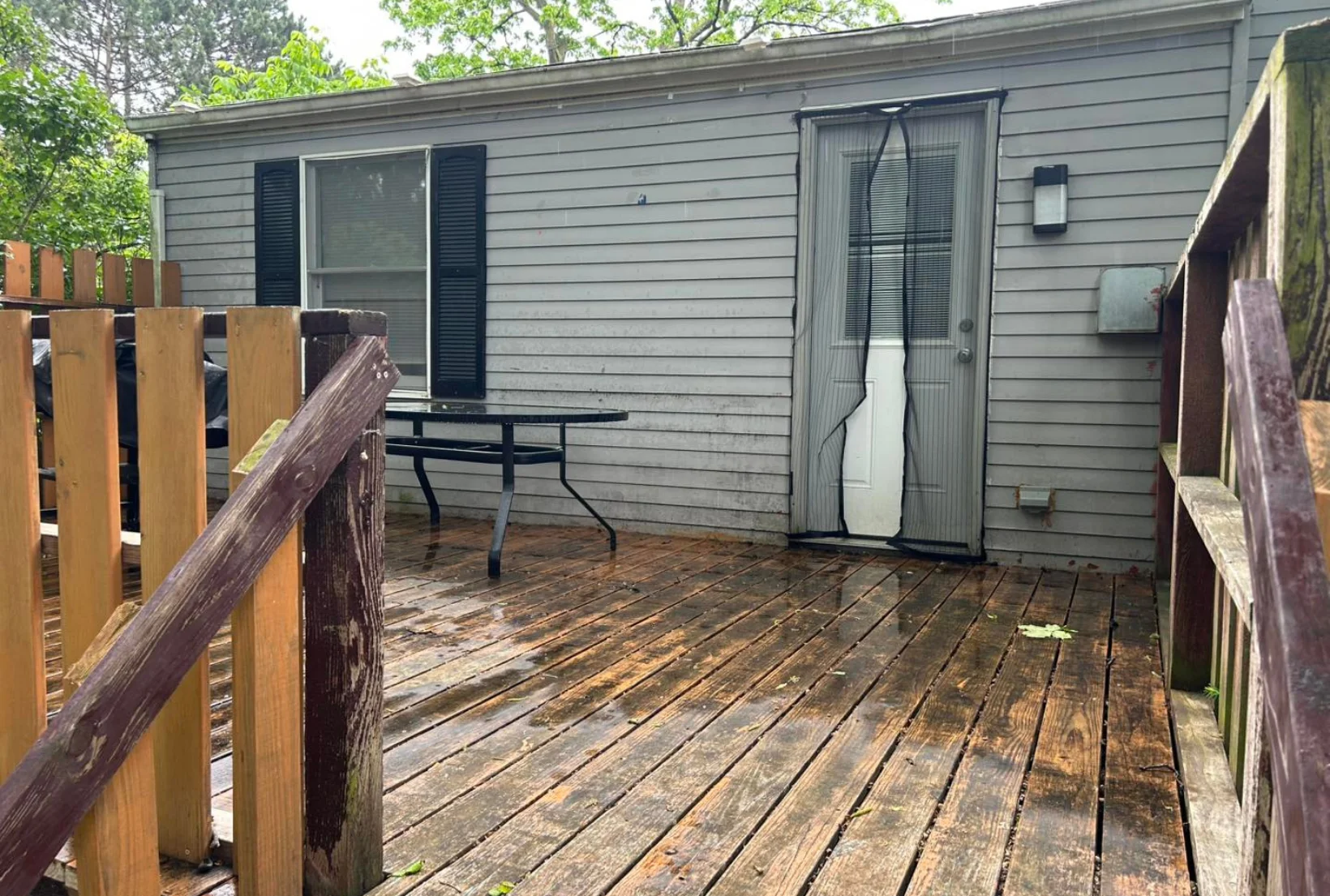 dirty-mildew-deck-before-cleaning-houston Dirty deck with mildew stains dark spots and weathered railings before professional deck cleaning service
