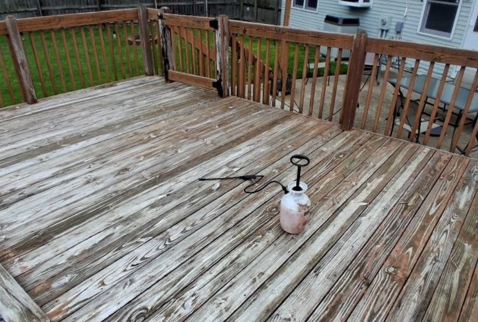 gray-weathered-poolside-deck-before-staining-houston Gray weathered poolside deck with faded boards and worn railings being prepped for professional deck staining