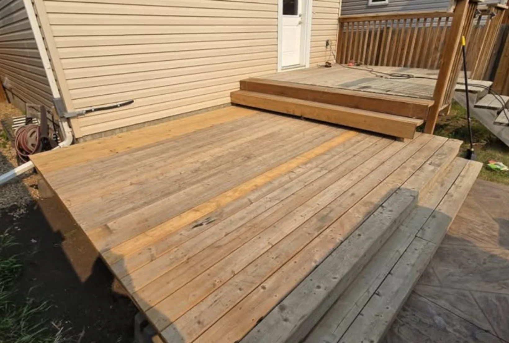 unstained-bare-wood-deck-before-staining-houston New bare wood deck with weathered gray steps awaiting professional deck staining service in Houston