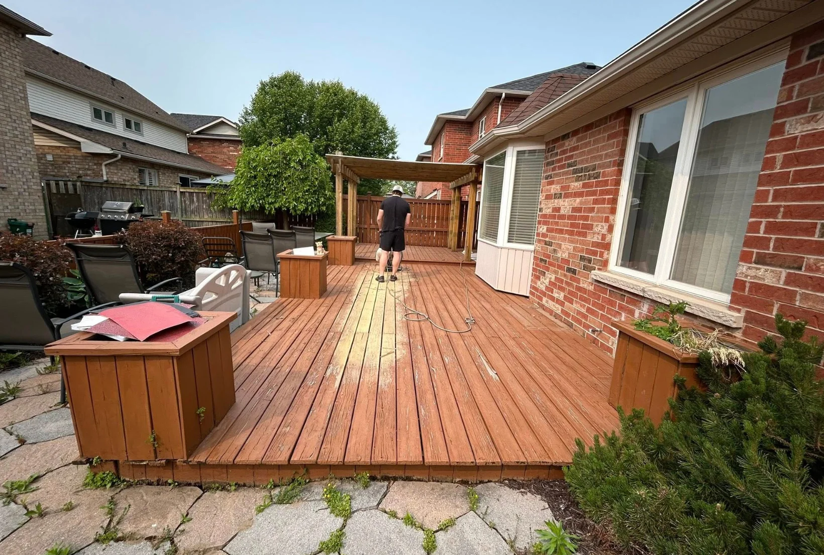 worn-peeling-deck-before-staining-houston Worn backyard deck with peeling stain and faded wood being prepped for professional deck staining restoration in Houston